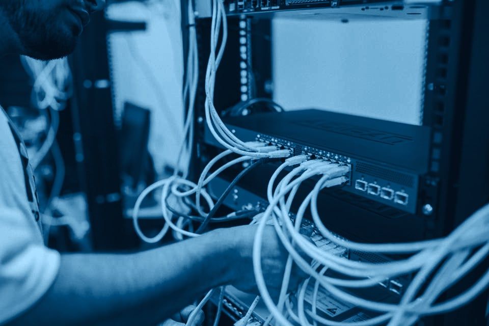 Especialista conectando cableado de red en un switch montado en rack