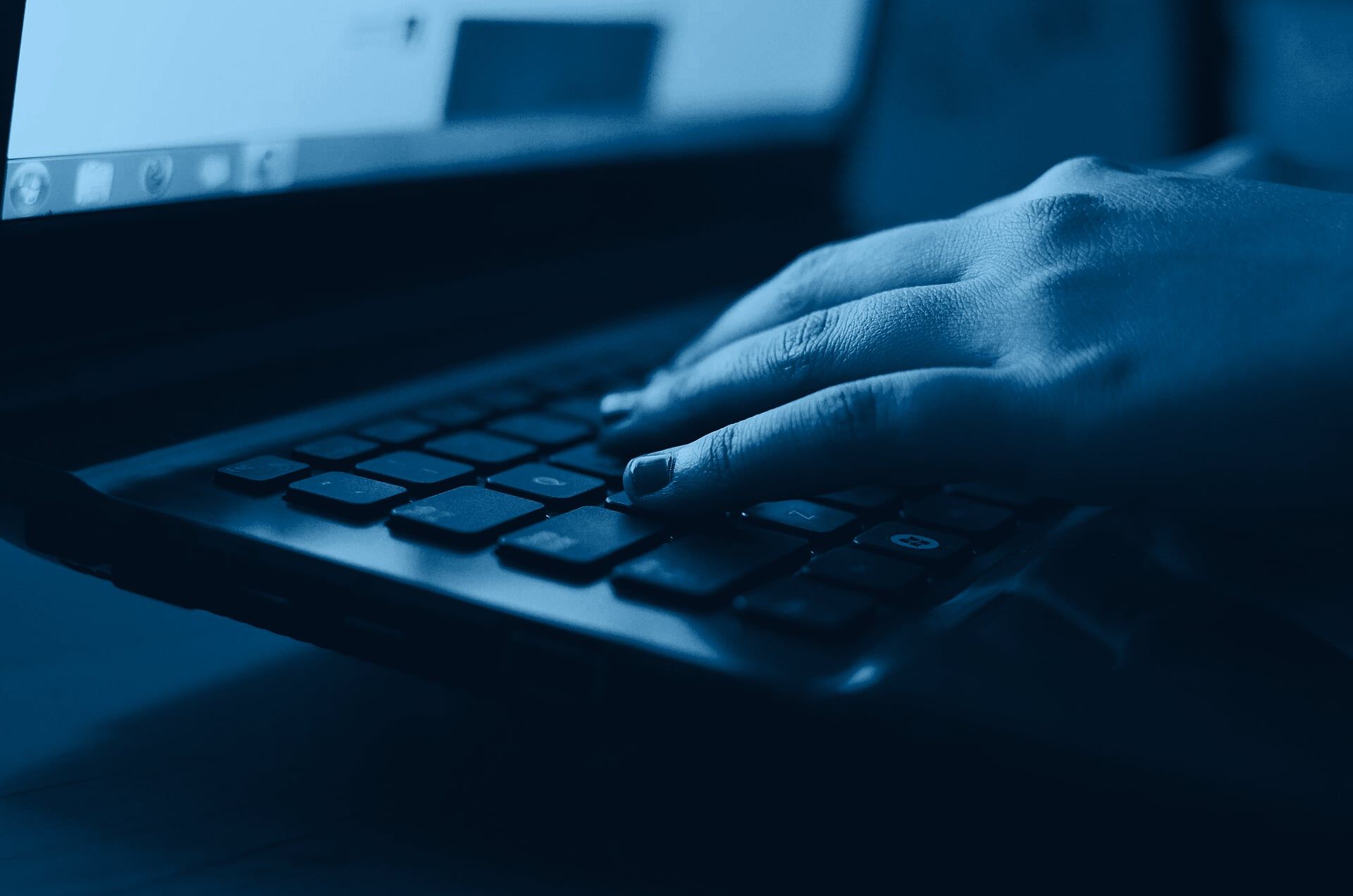 Manos escribiendo en el teclado de una laptop